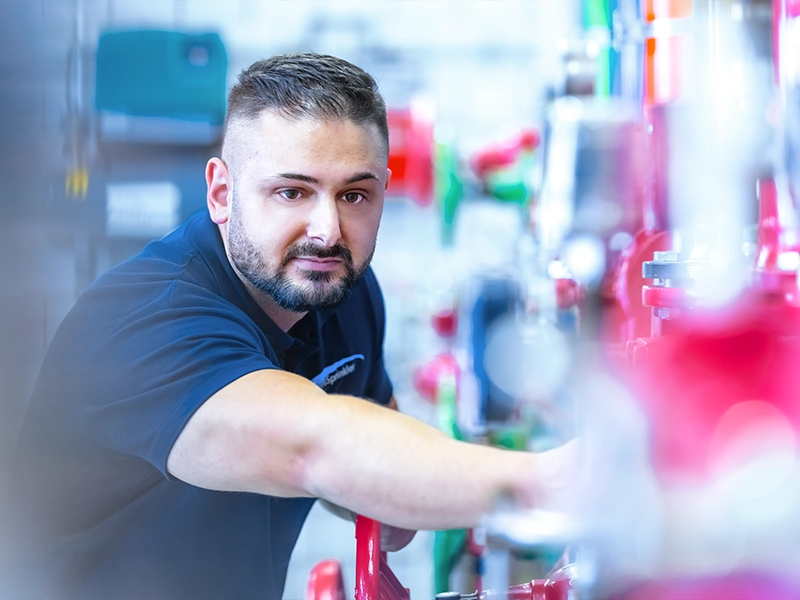 Das Foto aus dem Shooting für die EuroSprinklers Corporate Website zeigt einen Mitarbeiter bei der Bedienung von Maschinen. Es unterstreicht die technische Expertise und Präzision, die in der EuroSprinklers Markenkommunikation betont wird.